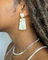 -Clay polymer 
-Cream base color
-Tan streak detail
-Gold flake detail
-Gold hoop connecting top piece to bottom piece
GOLD FLAKE CLAY DANGLE EARRING