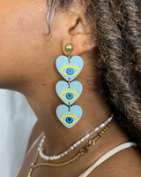 -Three heart dangle 
-Gold hoop connections
-Blue heart detail
-Navy & light blue eye detail
-Yellow eye & eyelash detail
TRI-HEART BLUE DANGLE EARRING